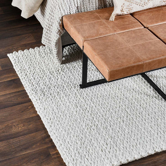 Ivory wool area rug with thick woven pattern and short fringed edges