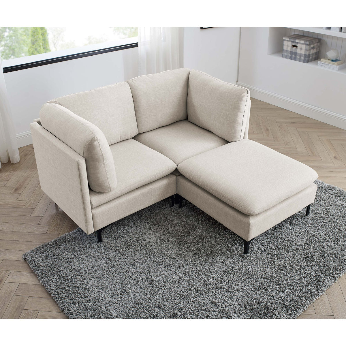 Beige upholstered sectional with tall legs, chaise ottoman, and corner seat cushion