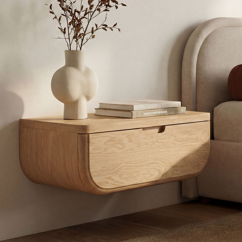 Wall-mounted floating nightstand with curved wood drawer and flat top surface.