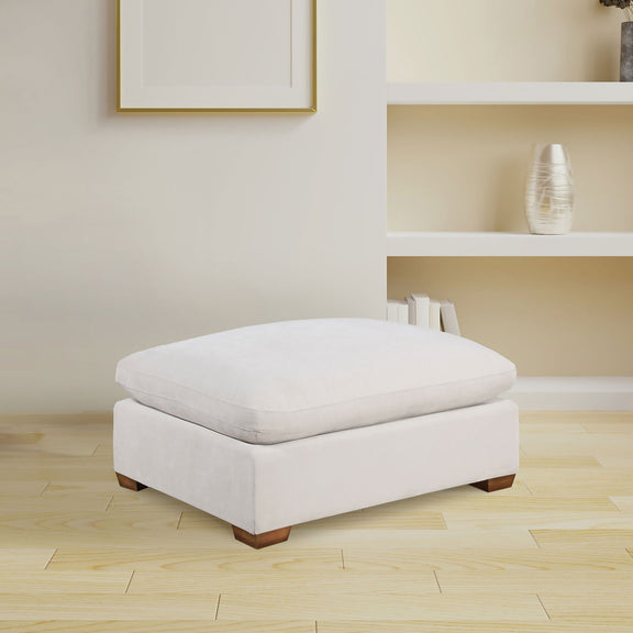 White upholstered ottoman with tufted-look top and wooden block feet.