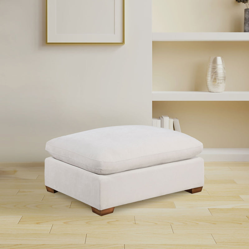White upholstered ottoman with tufted-look top and wooden block feet.