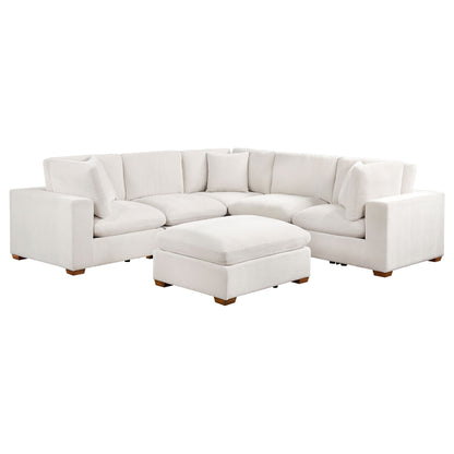 Beige modular sectional sofa with matching ottoman, curved corner layout