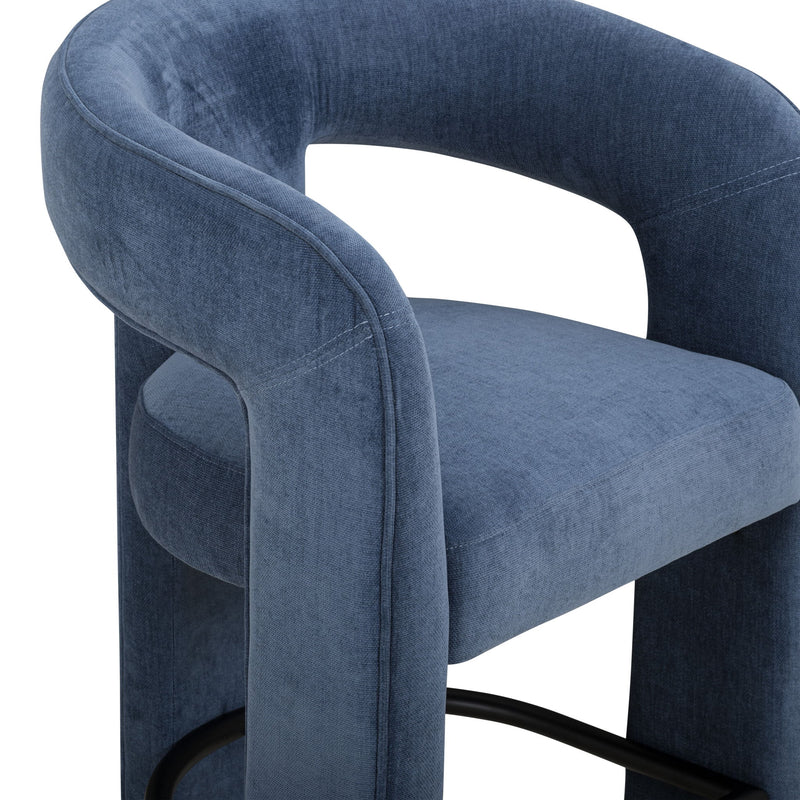 Blue upholstered stool close-up showing curved arms and black footrest