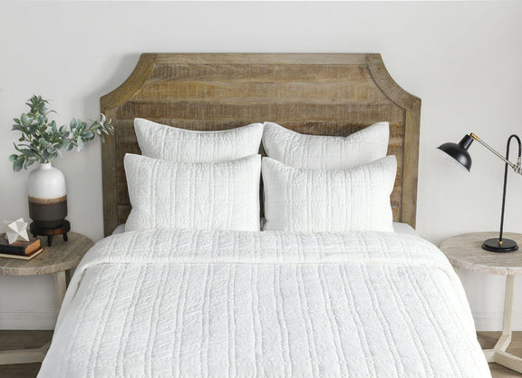 White quilt and pillows with vertical channel stitching and textured fabric