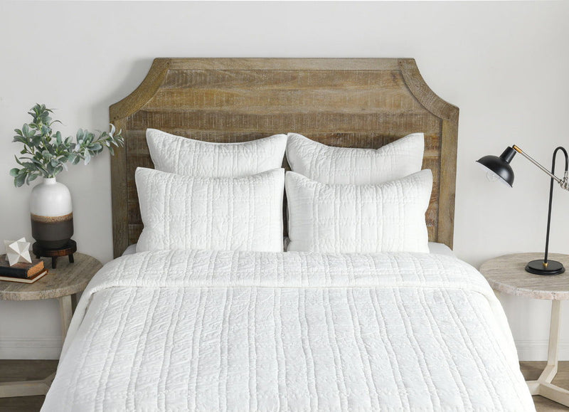 White quilt and pillows with vertical channel stitching and textured fabric