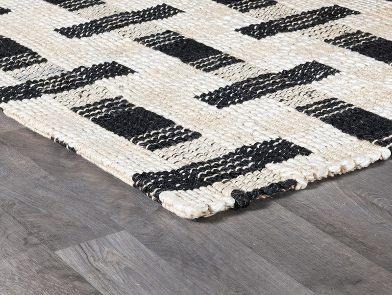 Ivory and black geometric rug with interlocking rectangular blocks, corner detail