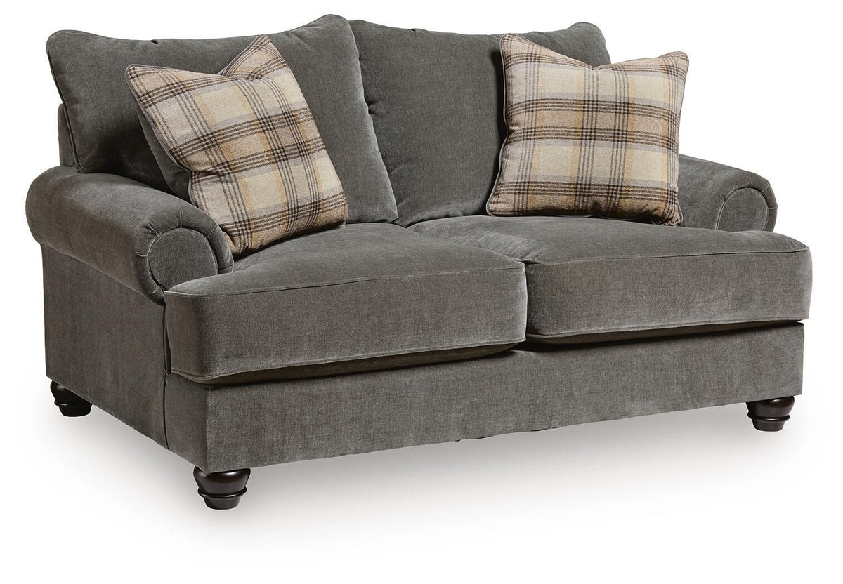 Gray fabric loveseat with roll arms, tufted back, and plaid throw pillows