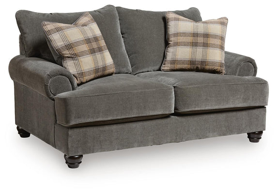 Gray fabric loveseat with roll arms, tufted back, and plaid throw pillows