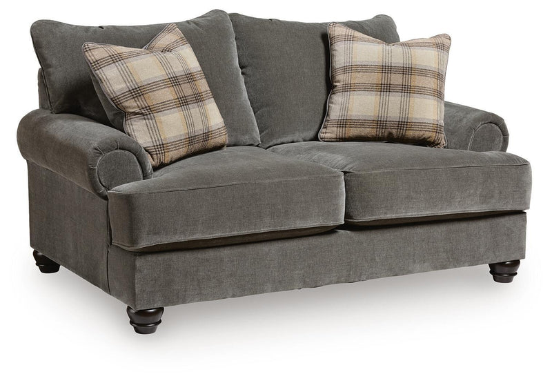 Gray fabric loveseat with roll arms, tufted back, and plaid throw pillows