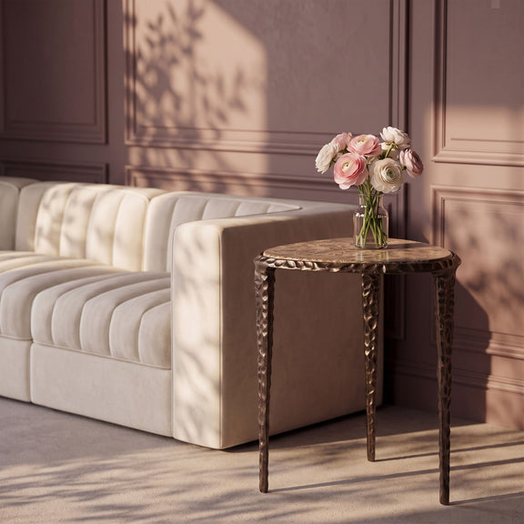 Round marble-top end table with dark metal legs, styled in a living room