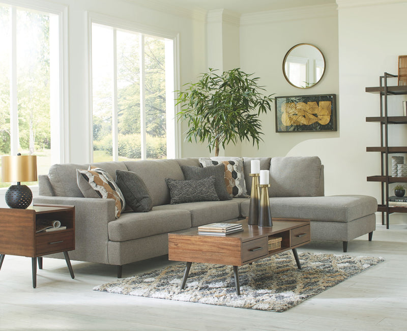 Gray sectional sofa with chaise, tufted cushions, and assorted throw pillows.