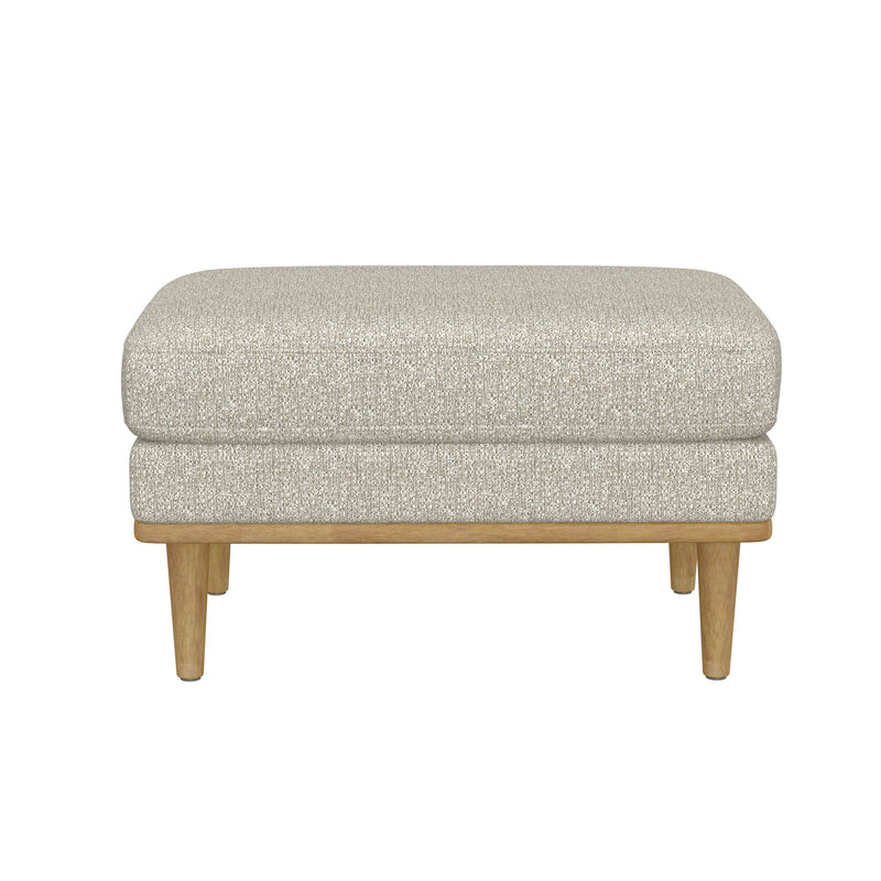 Tan upholstered ottoman with rounded cushion top and exposed wooden legs.