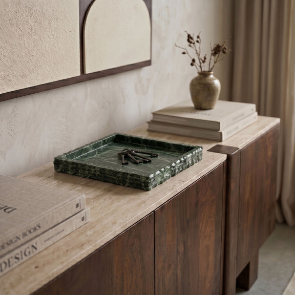Green marble tray on a countertop with white veining and squared raised rim.