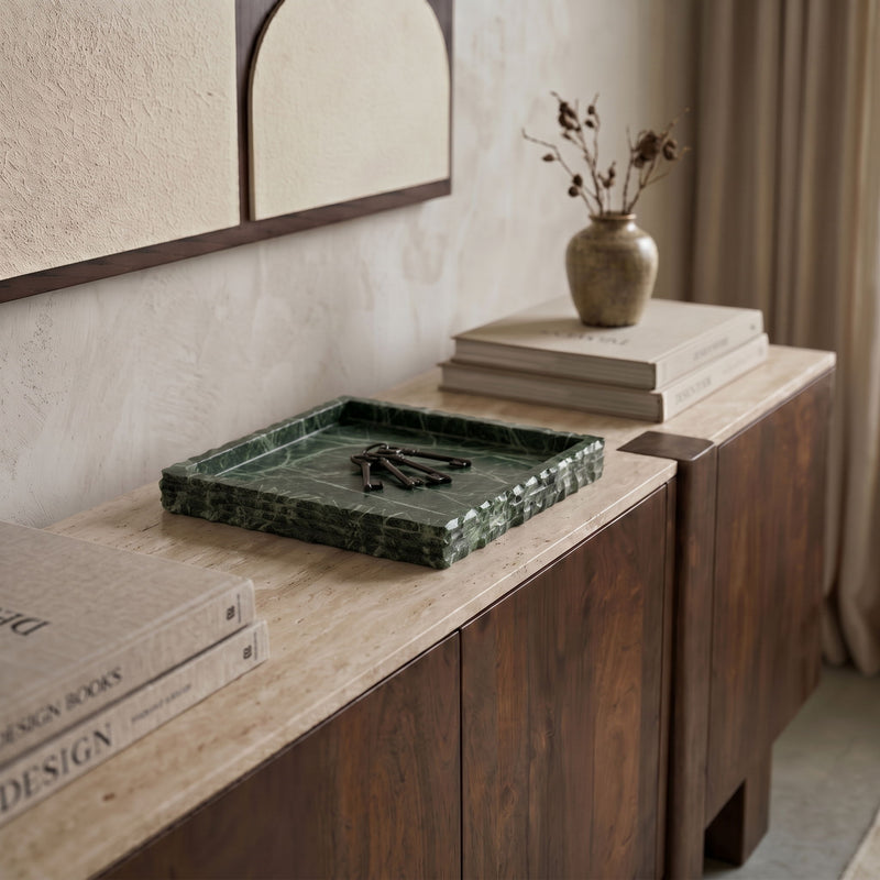 Green marble tray on a countertop with white veining and squared raised rim.