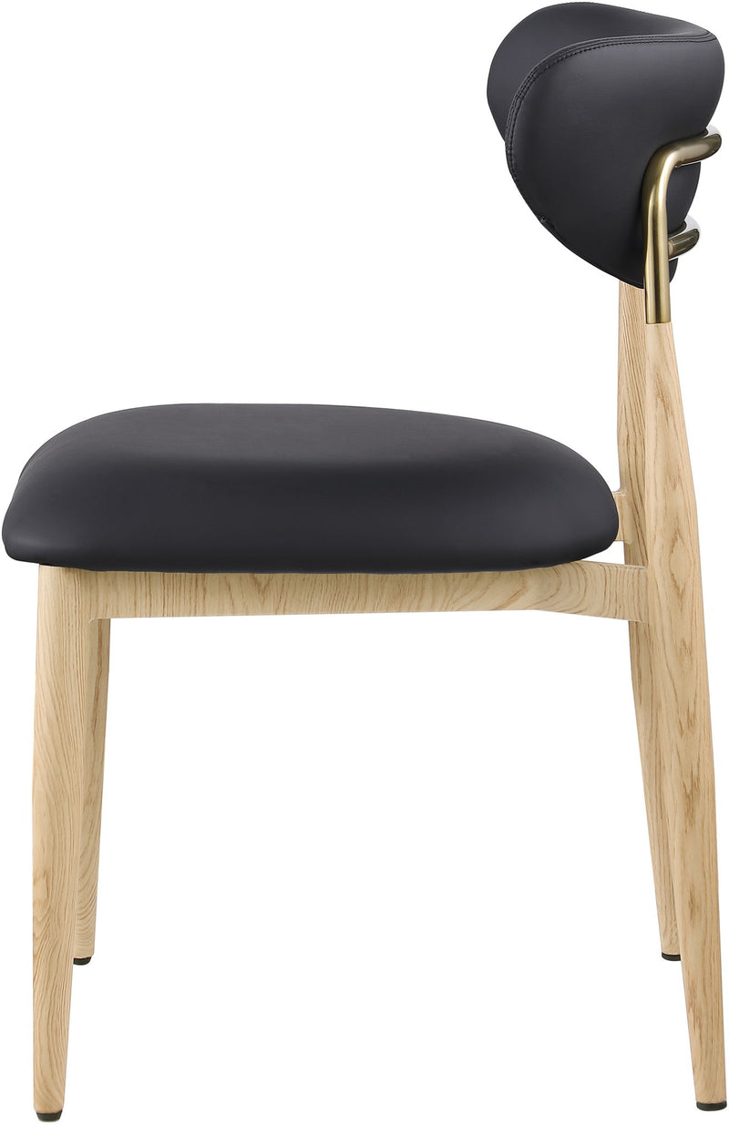 Dark upholstered dining side chair close-up with light wood legs and brass accents