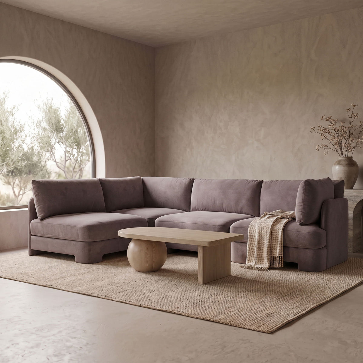 Dark gray velvet armless sectional sofa with rounded arms and built-in chaise seating