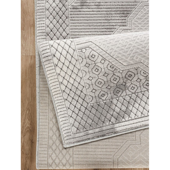 Gray geometric rug corner with stitched border and raised diamond texture