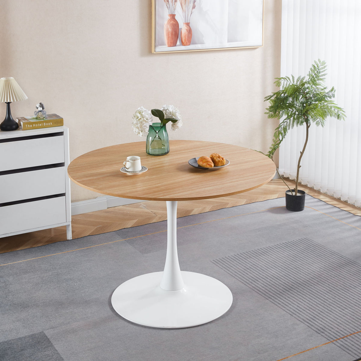 Light brown round tulip pedestal dining table with white pedestal base