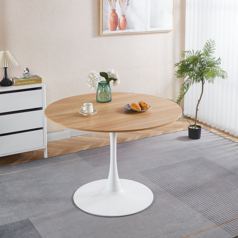 Light brown round tulip pedestal dining table with white pedestal base