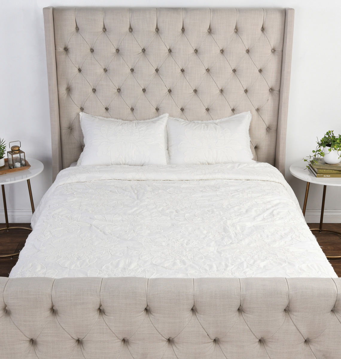 Antique cream comforter with quilted texture, neatly draped over bed