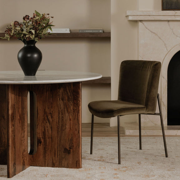 Green dining chair with a padded seat, curved back, and slim metal frame