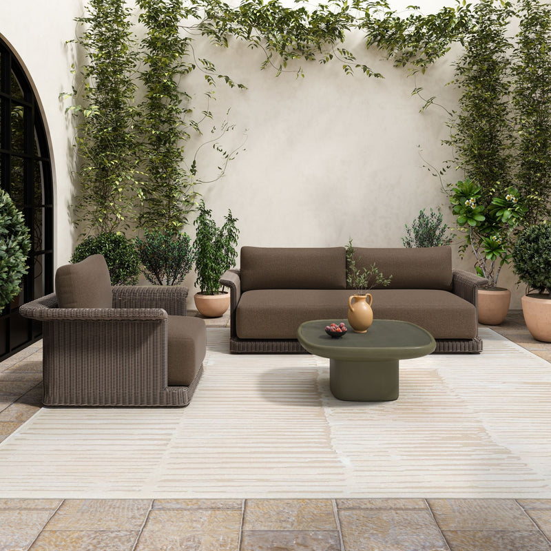 Deep green round outdoor coffee table with pedestal base on patio