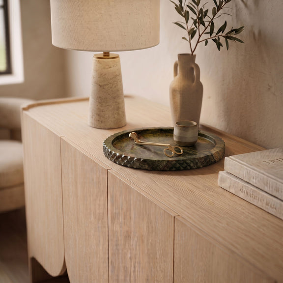 Beige marble tray on wooden vanity, textured scalloped edge visible.