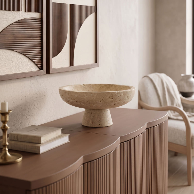 Beige travertine pedestal bowl on tabletop, round shallow basin