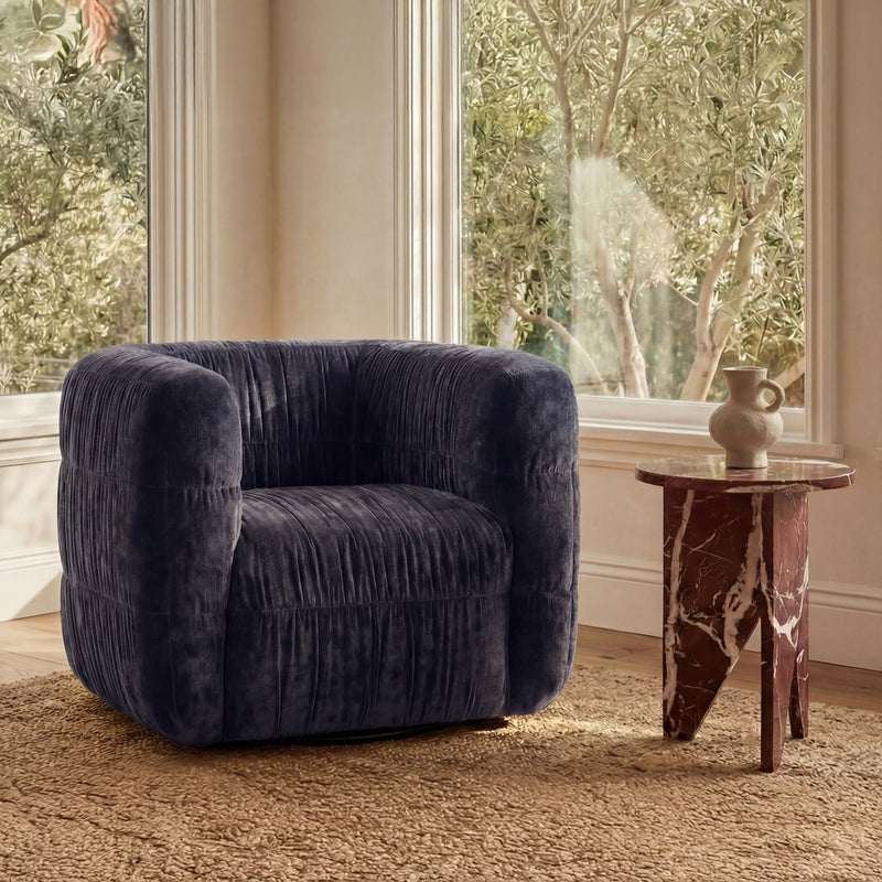 Navy swivel chair upholstered in plush fabric with rolled arms and cushioned seat