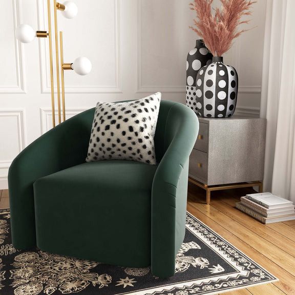 White and black spotted pillow on green armchair, plush fur