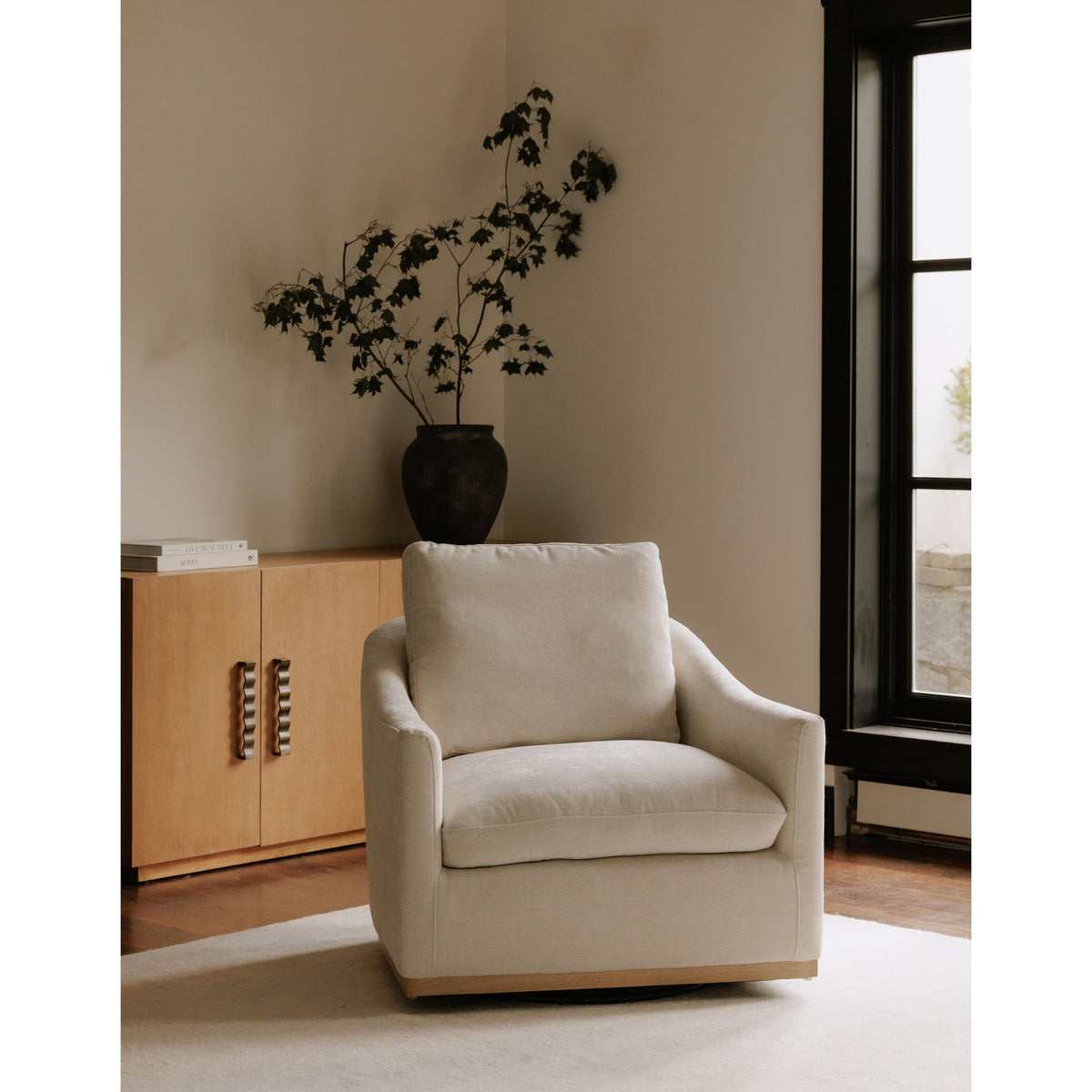 Beige fabric swivel armchair with thick seat cushion and wooden base