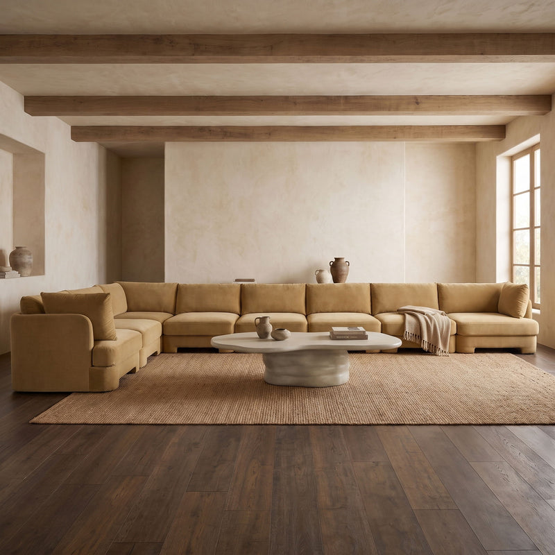 Beige velvet L-shaped sectional sofa with multiple seat sections and a chaise