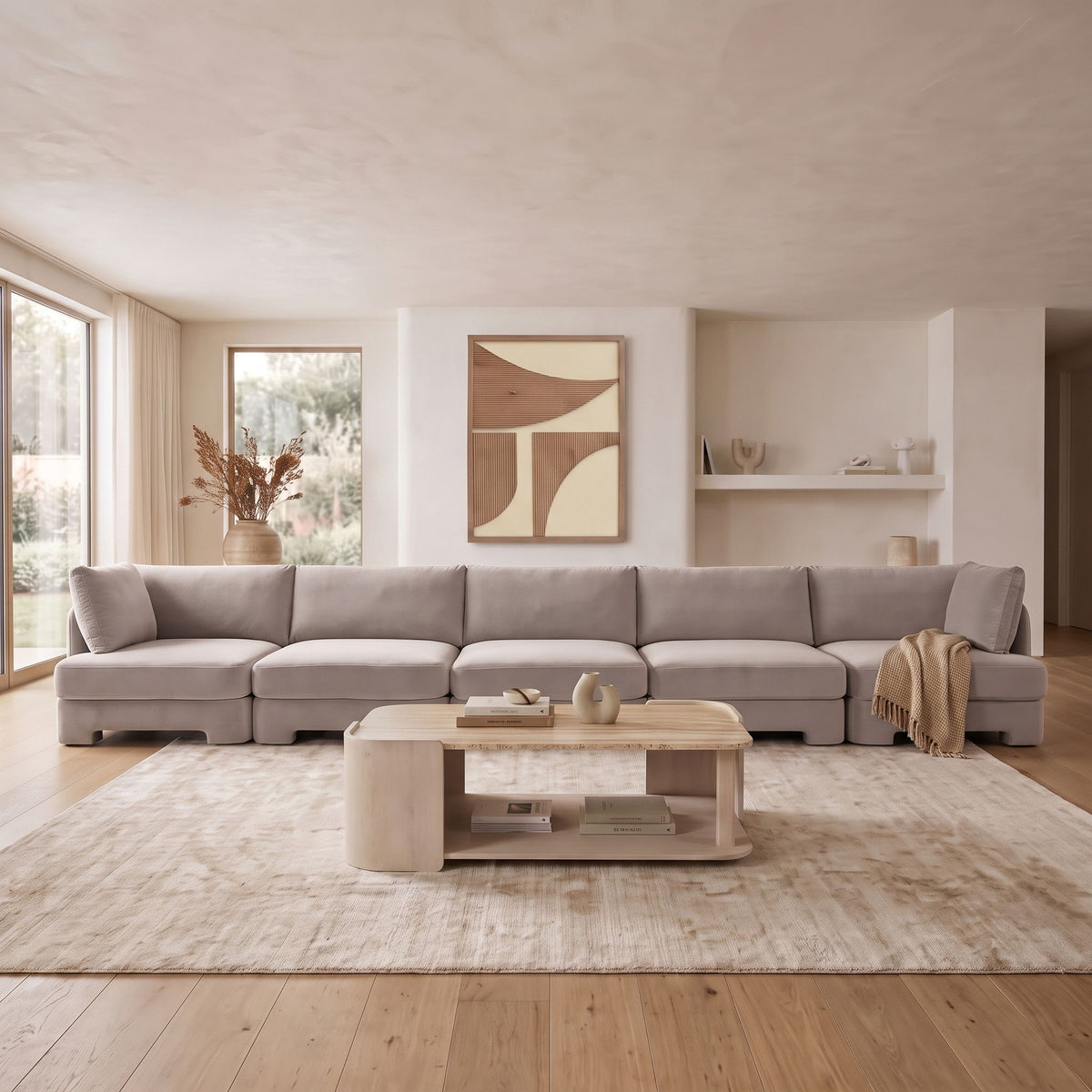 Light gray velvet sectional sofa with corner module and visible throw on the arm