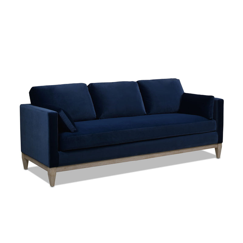 Navy modern farmhouse sofa with boxy back cushions and tapered wood legs.