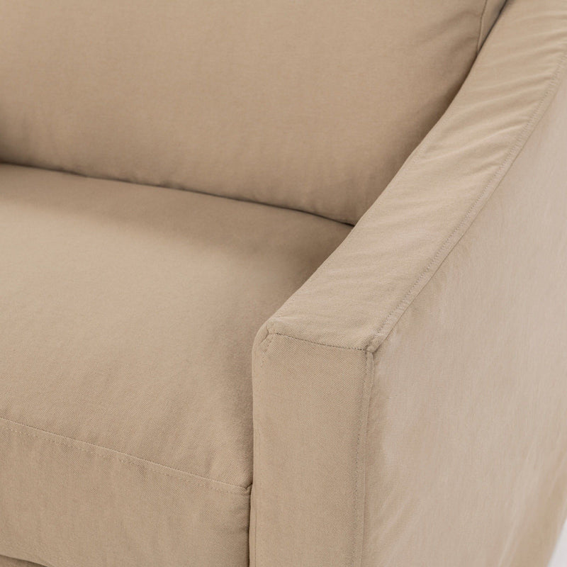 Close-up of upholstered arm and seat seams in beige fabric