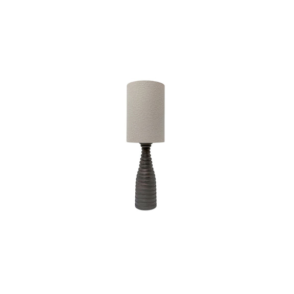 Table lamp with textured beige cylinder shade and dark ribbed pedestal base
