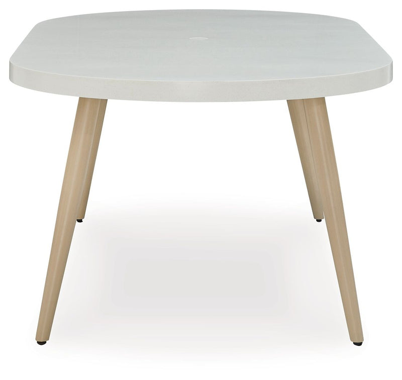 White oval dining table with rounded edge and tapered wood legs