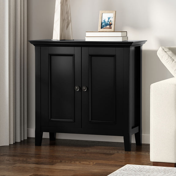 Black two-door storage cabinet with paneled doors and round metal knob pulls