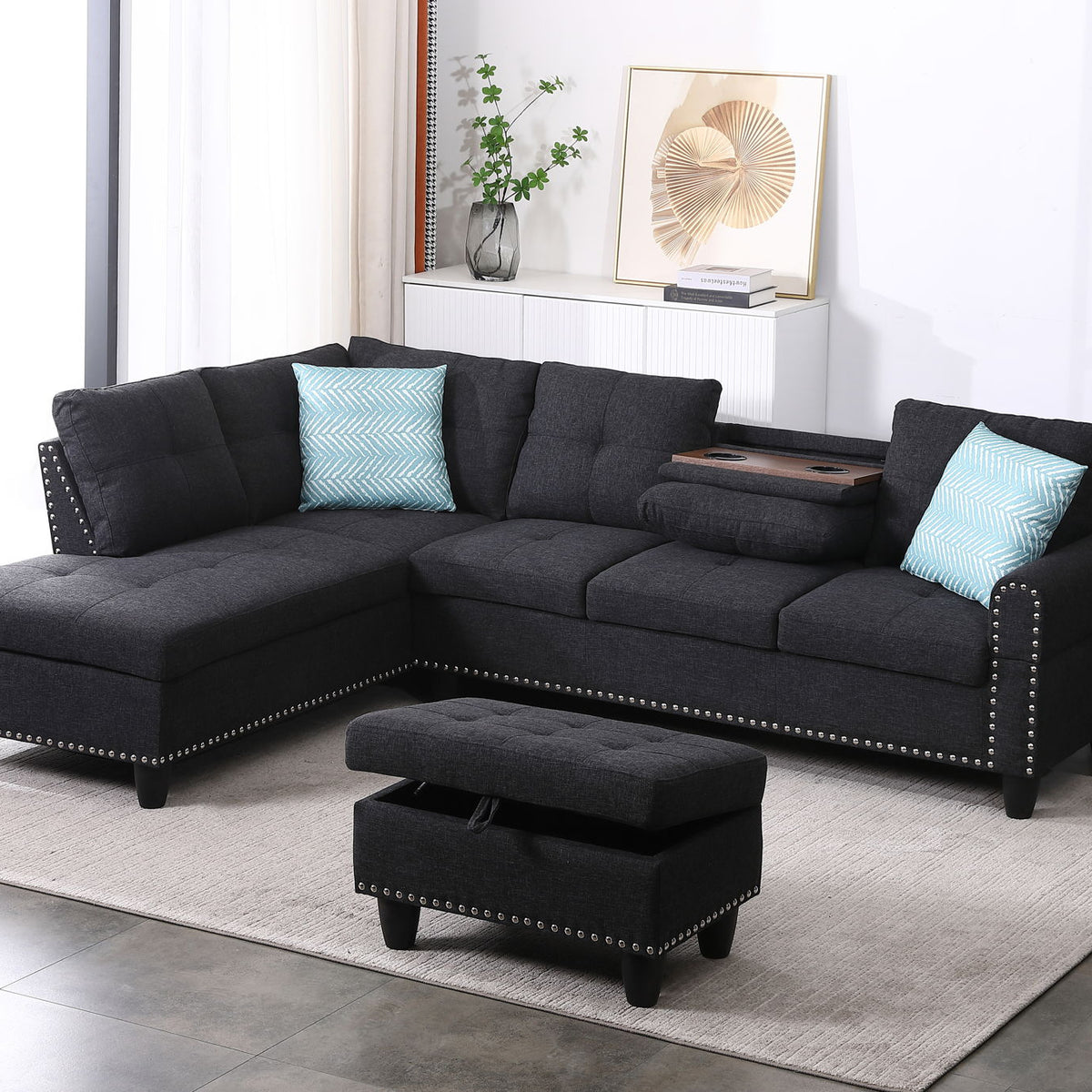 Dark gray sectional sofa with left-facing chaise and ottoman, tufted cushions and blue pillows
