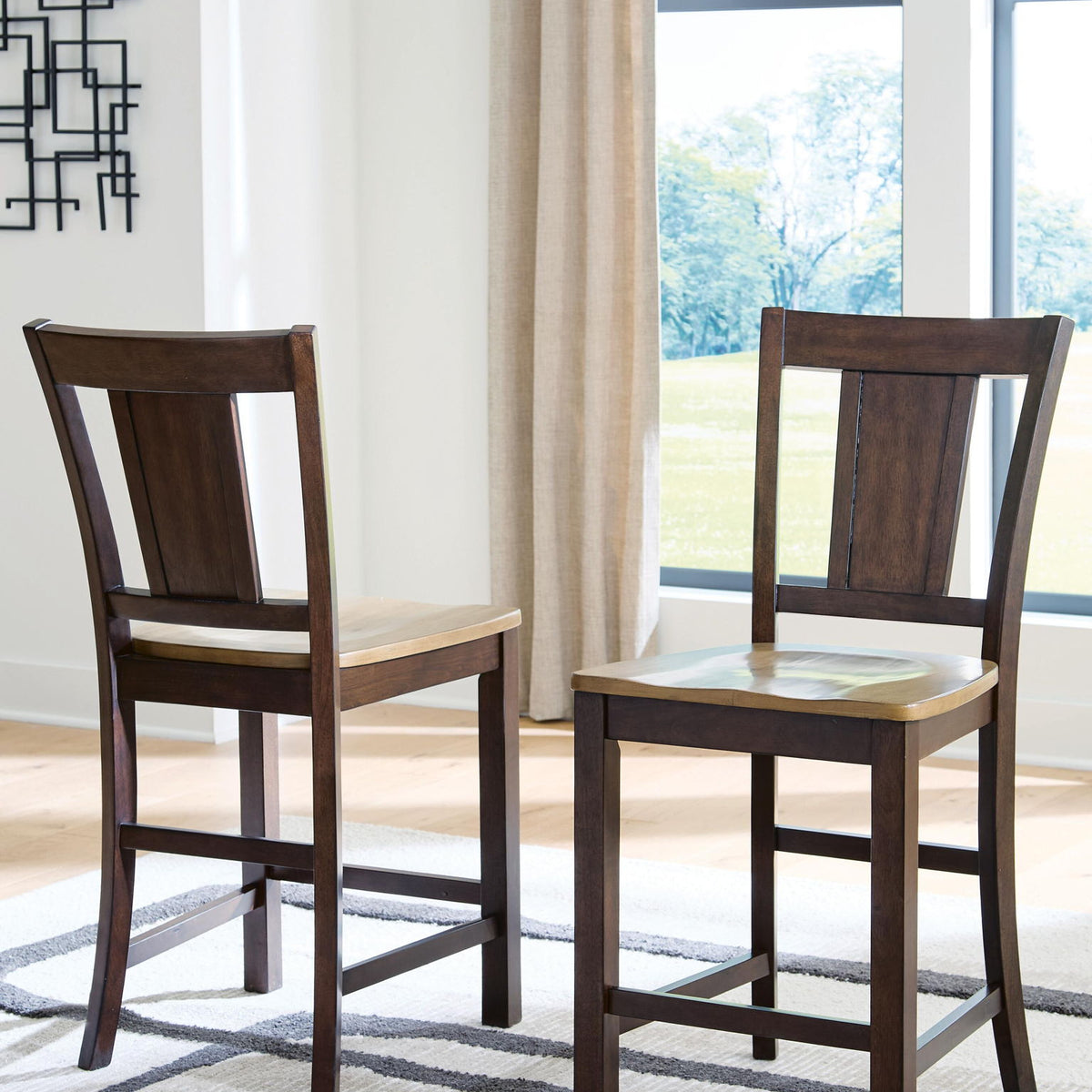 Two dark brown wooden barstools with open-frame legs and slatted backs, light seats