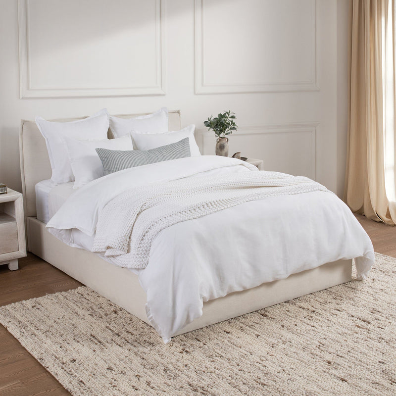 Set of white solid sham pillows with a stitched border on a bed