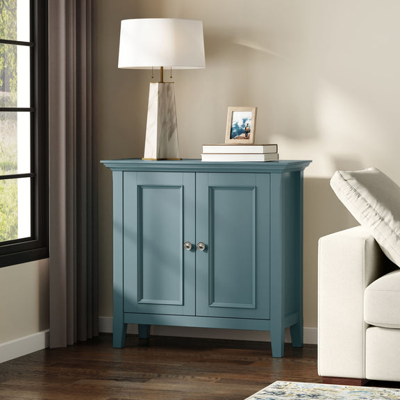 Blue two-door storage cabinet with paneled doors and round metal knob pulls