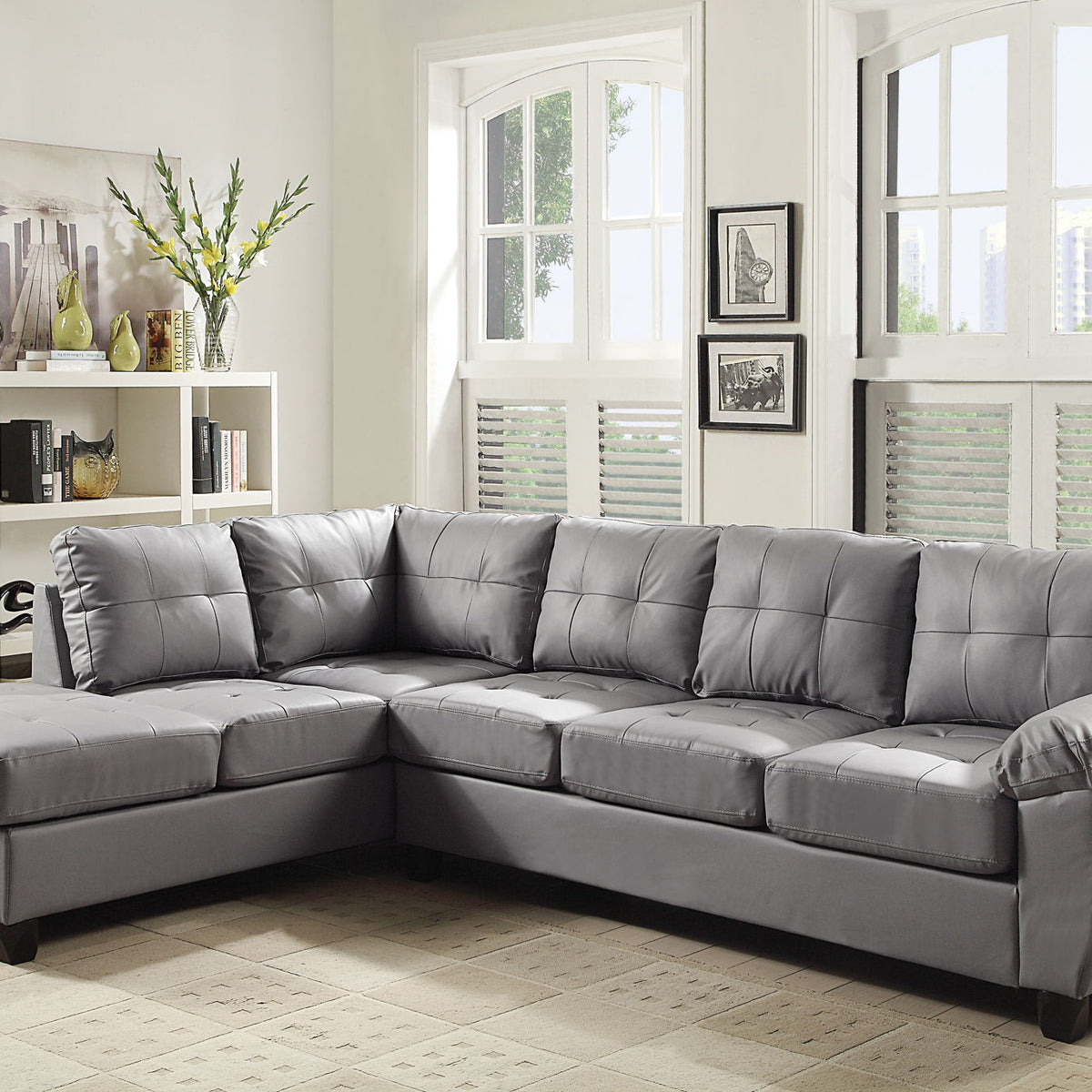 Gray faux leather sectional sofa with tufted back, deep seats, and tapered legs