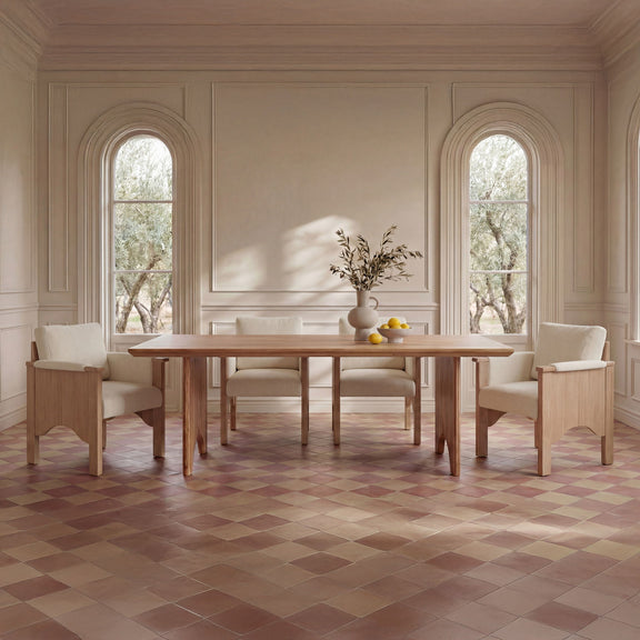 Pair of cream upholstered dining chairs with light wood frames beside a table