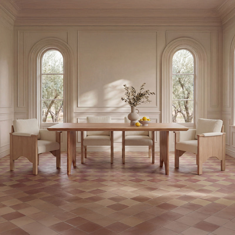 Pair of cream upholstered dining chairs with light wood frames beside a table
