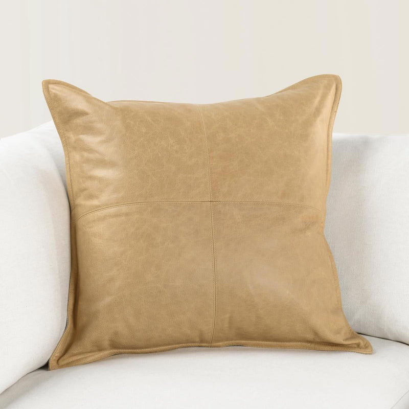 Golden tan leather lumbar pillow with center seam and square-edge stitching.
