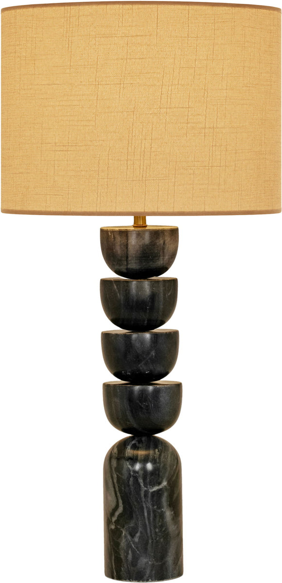 Table lamp with stacked dark marble base and tan fabric drum shade, brass accents