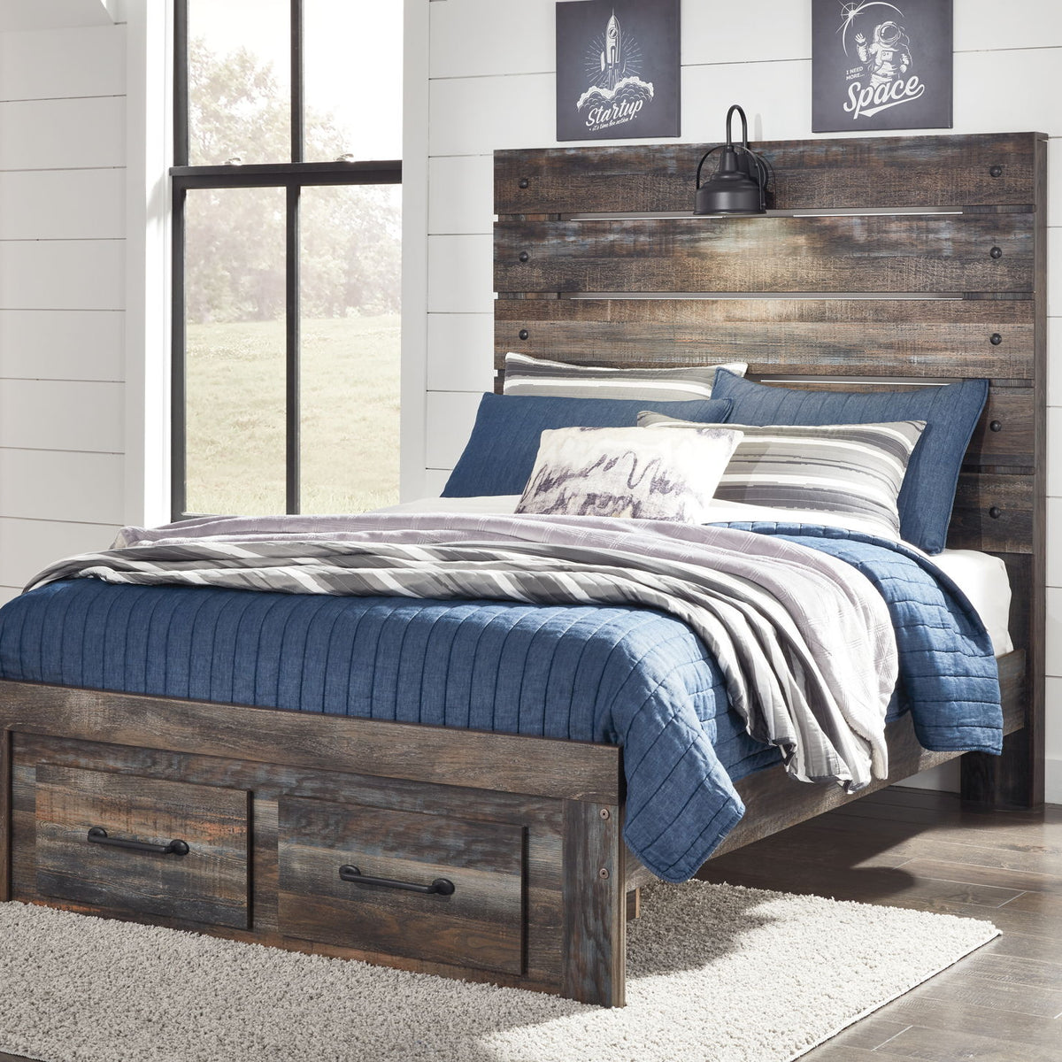 Drystan panel bed with dark wood frame and side drawers, topped with blue bedding and pillows.