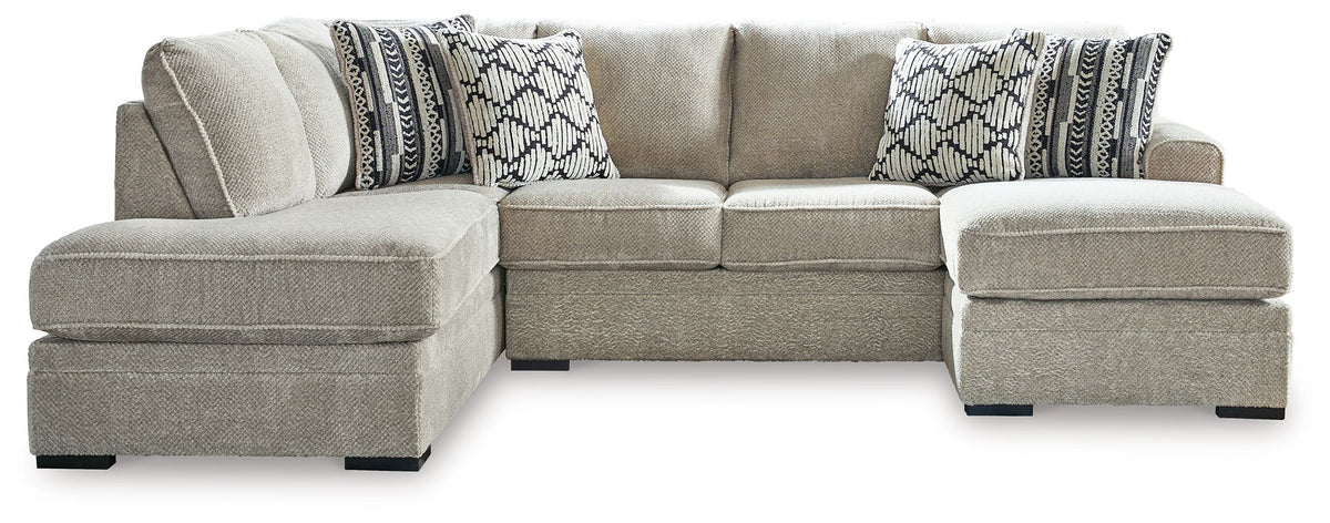 Beige corner chaise sectional sofa with chaise extension and two patterned lumbar pillows