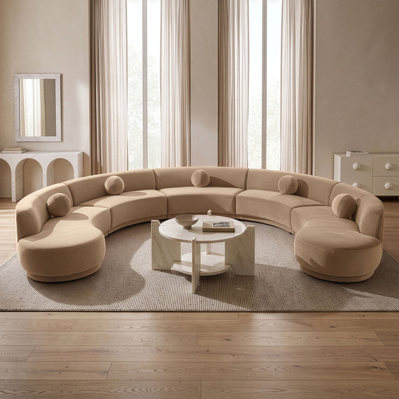 Beige performance velvet sectional sofa with rounded ottoman-style sections and bolsters